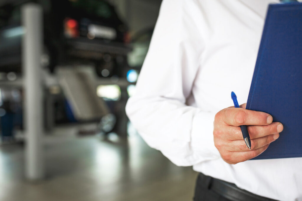 KFZ Gutachter Zentrale| master receptionist car service station with tablet recording repairs maintenance