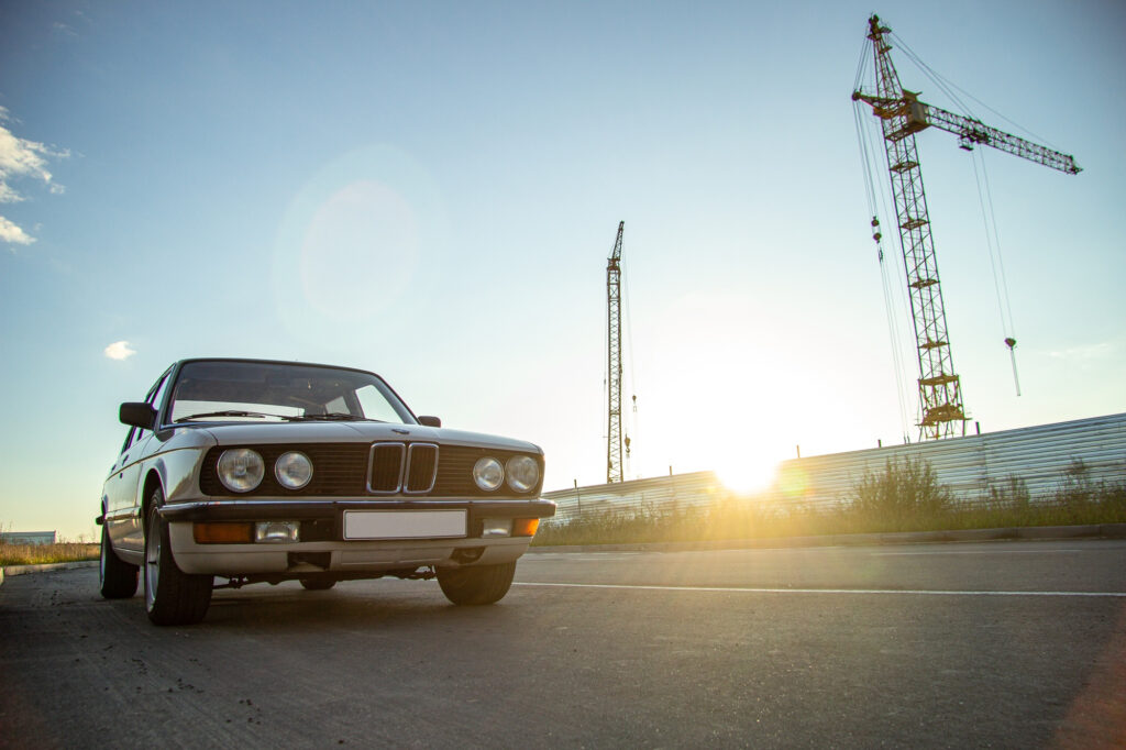 KFZ Gutachter Zentrale| white vintage classic car with round headlights road during sunset